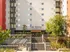 Modern The Quad on Delaware apartment exterior with inviting entrance, surrounded by lush greenery and contemporary design.