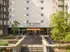 Inviting entrance of The Quad on Delaware featuring modern architecture and lush greenery.
