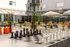 Modern outdoor leisure area with giant chess set, vibrant seating, and umbrellas for a relaxed ambiance.