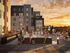 Vibrant rooftop scene with people enjoying a stylish hot tub and lounge area against a stunning sunset backdrop.