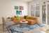 Chic living room with a stylish brown leather sofa, vibrant decor, and a bright atmosphere, complemented by a stunning blue-patterned rug and modern wall art.