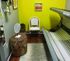 Stylish room with tanning bed, wicker furniture, and bright yellow accent wall.