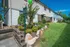 Charming townhouse exterior with lush landscaping and future resident parking sign, under a clear blue sky.