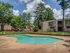 Inviting apartment complex with a refreshing outdoor swimming pool, surrounded by lush greenery and modern living spaces.