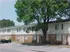 Townhome building with a large shade tree at Bent Creek Apartments in West Memphis, AR