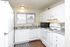 White kitchen with white appliances and wood-style floors at Braewood in Murray, UT