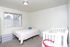 Second bedroom with a full bed and a white crib at Braewood in Murray, UT