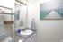 Bathroom vanity with open shelving and ocean wall art at Braewood in Murray, UT