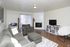 Living area with a gray sofa, fireplace and TV stand at Braewood in Murray, UT