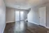 Living room with patio doors and wood-style floors at Collier Village Apartments in Collierville, TN