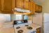Kitchen with electric range and wood cabinets at Collier Village Apartments in Collierville, TN