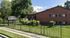 Green lawn and iron fence lining the brick apartments at Fairbrook in Salt Lake City, UT