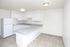 White kitchen with a peninsula counter and tile floors at Fairbrook in Salt Lake City, UT