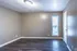 Empty room with wood-style floors and a tall window at Hunter Oaks Apartments in Memphis, TN