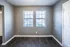 Living room with gray walls and twin windows at Jackson Heights Residential in West Memphis, AR