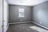 Carpeted bedroom with gray walls and a window at Jackson Heights Residential in West Memphis, AR