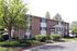 Brick apartments with tall shade trees and landscaping at Linden Colonial in Holladay, UT