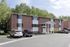 Brick building and resident parking lot on a sunny day at Linden Colonial in Holladay, UT