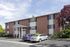 Wide view of brick apartments and open parking at Linden Colonial in Holladay, UT