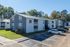 Apartment buildings with green lawn and parking at Meadow Creek Apartments in Jackson, MS