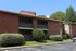 Two-story brick building with balconies and parking at Meadow Creek Apartments in Jackson, MS