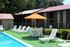 Pool deck with umbrella tables and loungers at Meadow Creek Apartments in Jackson, MS