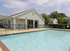 Sparkling outdoor pool and clubhouse at Meadows West Memphis Apartments in West Memphis, AR