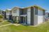 Two-story gray townhome building with green lawn at Pines Apartments in Jackson, MS