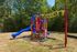 Colorful playground with slide surrounded by trees at Pines Apartments in Jackson, MS