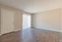 Empty living room with wood-style floors and sliding door at Pines Apartments in Jackson, MS