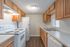 Kitchen with wood cabinets and white appliances in a 2 bedroom townhome at Pines Apartments in Jackson, MS