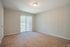 Carpeted bedroom with sliding glass door at Pines Apartments in Jackson, MS