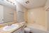 1 bedroom bathroom with tiled tub surround and wide mirror at Pines Apartments in Jackson, MS