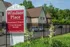 Red community sign beside iron fencing and greenery at Windsor Place Apartments in Memphis, TN