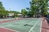 Outdoor tennis court surrounded by trees at The Meadows Apartments in Memphis, TN