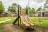 Playground with a yellow slide and green lawn at Hickory Pointe in Memphis, TN