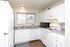 White kitchen with white appliances and wood-style floors at Braewood in Murray, UT