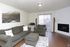 Living room with a gray sofa and an electric fireplace at Braewood in Murray, UT