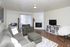 Living area with a gray sofa, fireplace and TV stand at Braewood in Murray, UT