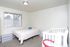 Second bedroom with a full bed and a white crib at Braewood in Murray, UT