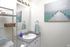 Bathroom vanity with open shelving and ocean wall art at Braewood in Murray, UT