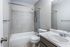 Bathroom with tiled tub and shower at Collier Village Apartments in Collierville, TN
