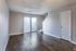 Living room with patio doors and wood-style floors at Collier Village Apartments in Collierville, TN