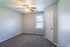 Carpeted primary bedroom with ceiling fan at Collier Village Apartments in Collierville, TN