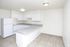 White kitchen with a peninsula counter and tile floors at Fairbrook in Salt Lake City, UT