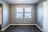 Living room with gray walls and twin windows at Jackson Heights Residential in West Memphis, AR