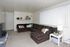 Living room with a brown sectional and vertical blinds at Linden Colonial in Holladay, UT