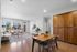 Modern open-plan living and dining area with elegant wood flooring and natural light, featuring cozy seating and stylish decor.