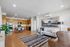 Contemporary apartment interior featuring an open-concept kitchen and living room with sleek wooden cabinetry, modern appliances, cozy seating, and stylish decor.