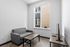 Cozy modern apartment living room with sleek gray couch, minimalistic decor, and large window for natural light.